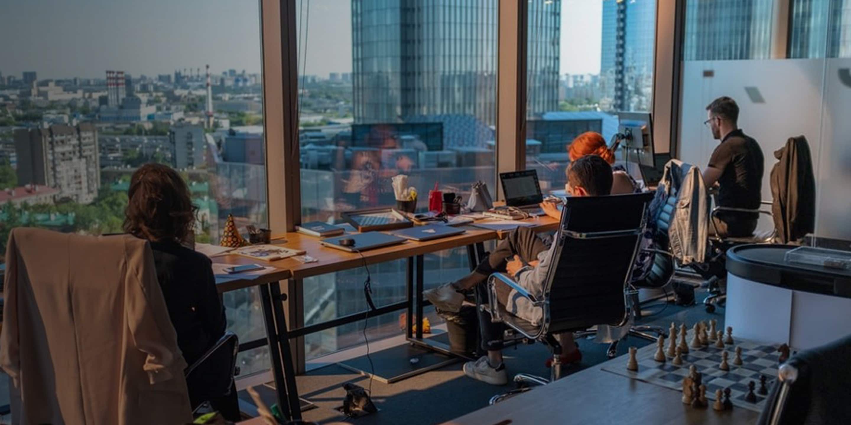 Employees in meeting, sitting at conference room table.