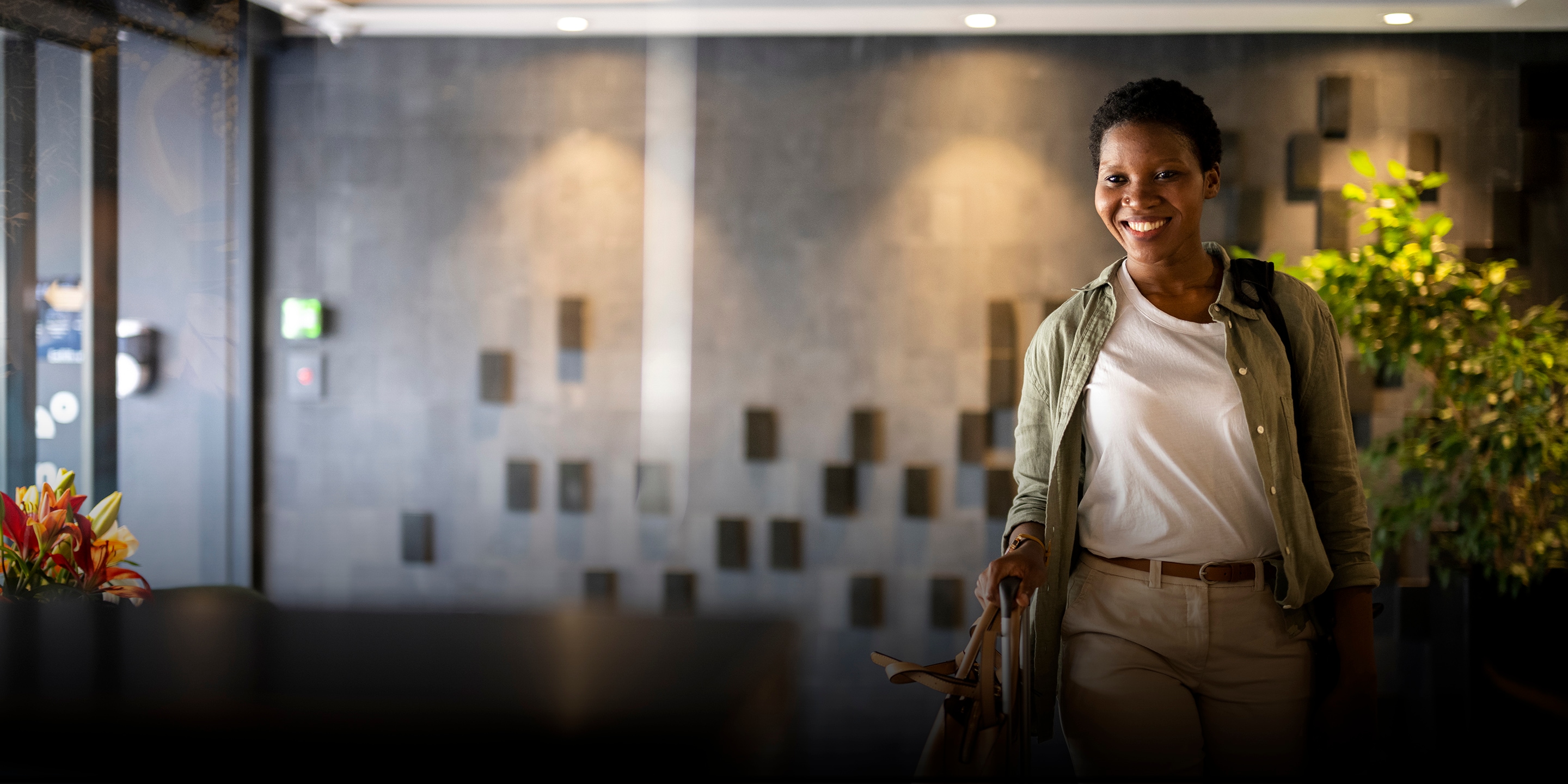 Confident young woman arriving in hotel reception