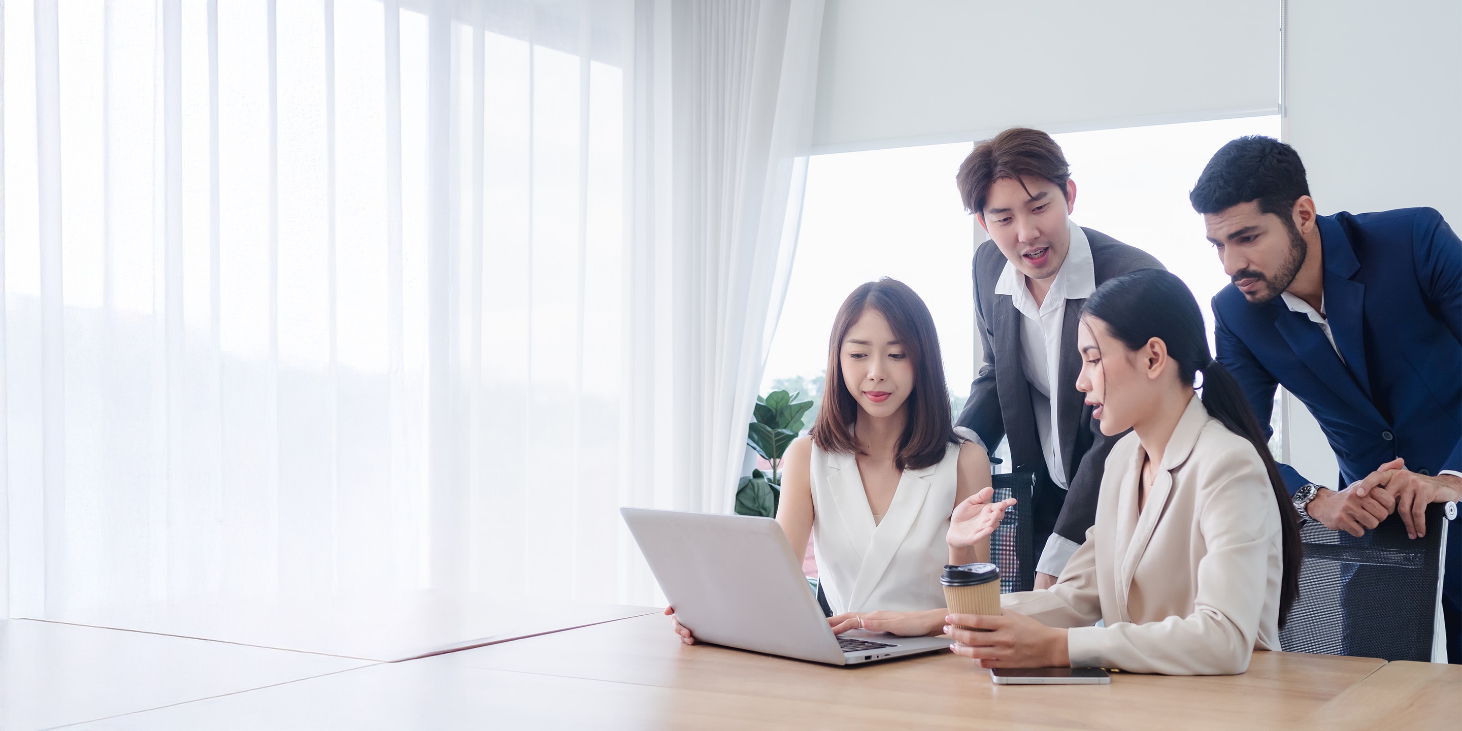 People meeting and talking by a computer
