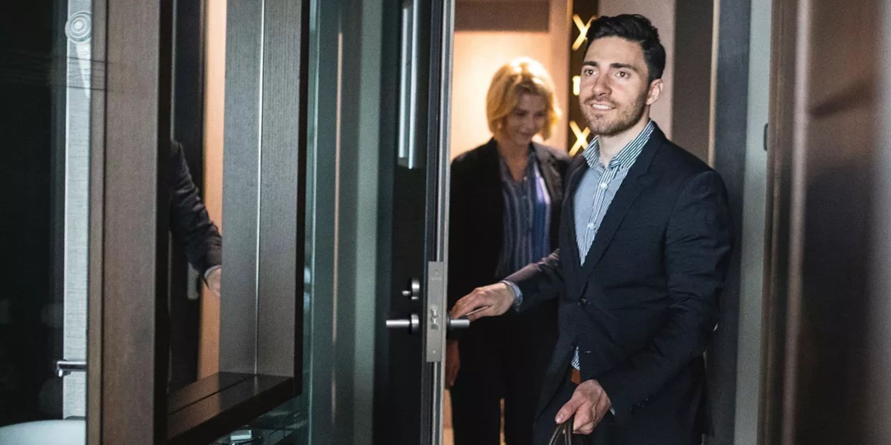 Man and woman entering a hotel room with bags
