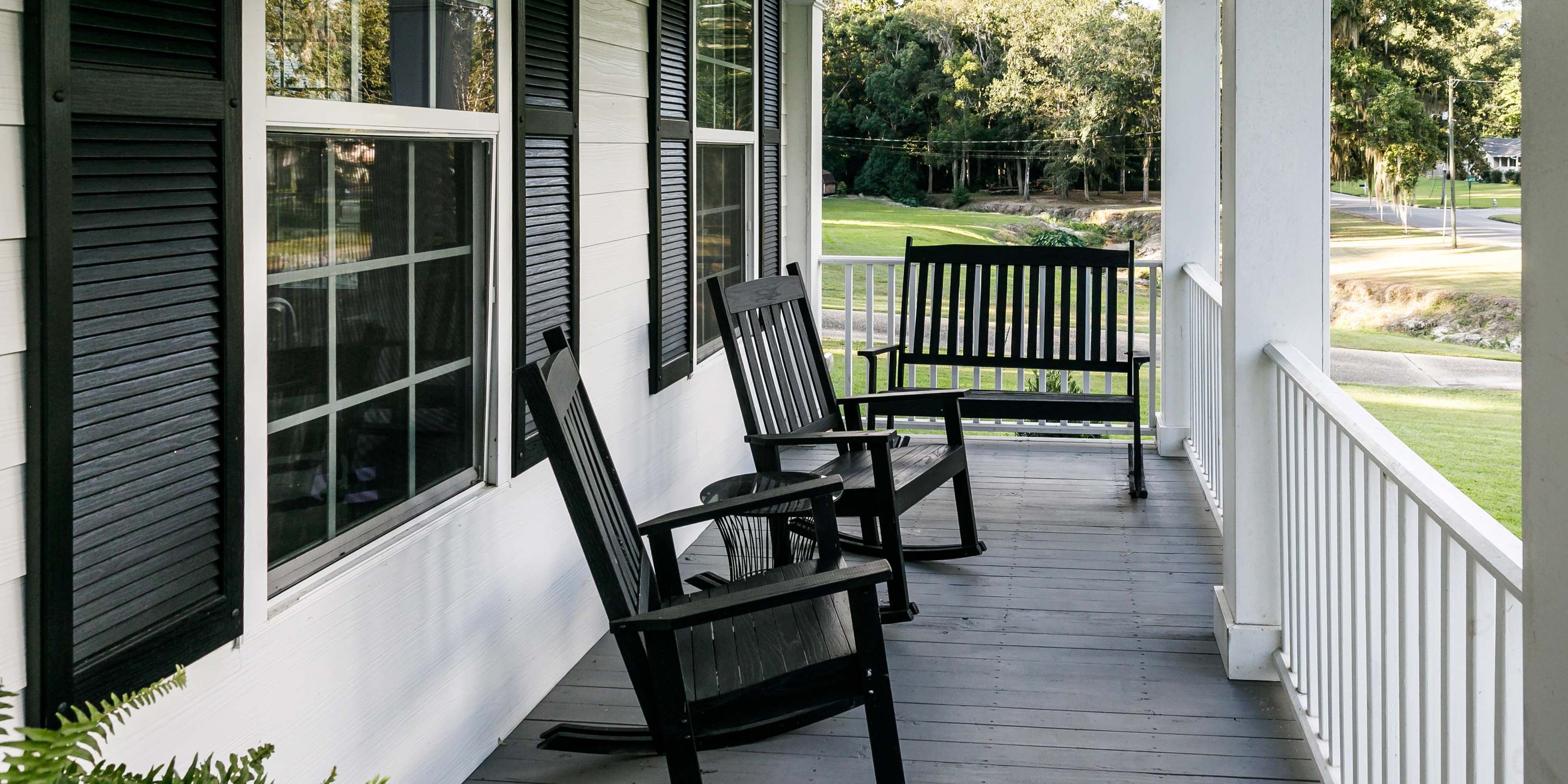 Side view of front porch with rocking chairs and bench