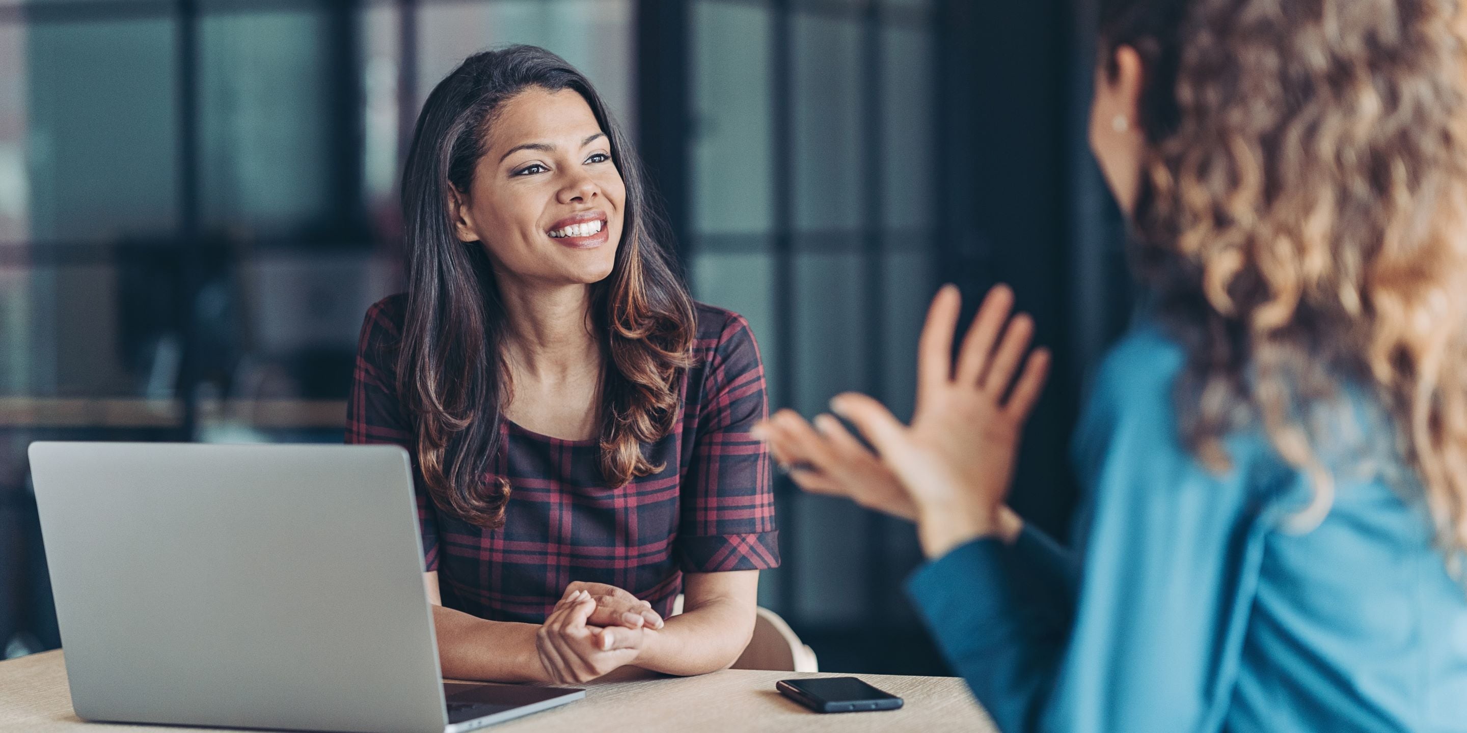 Two female business women talking in office
