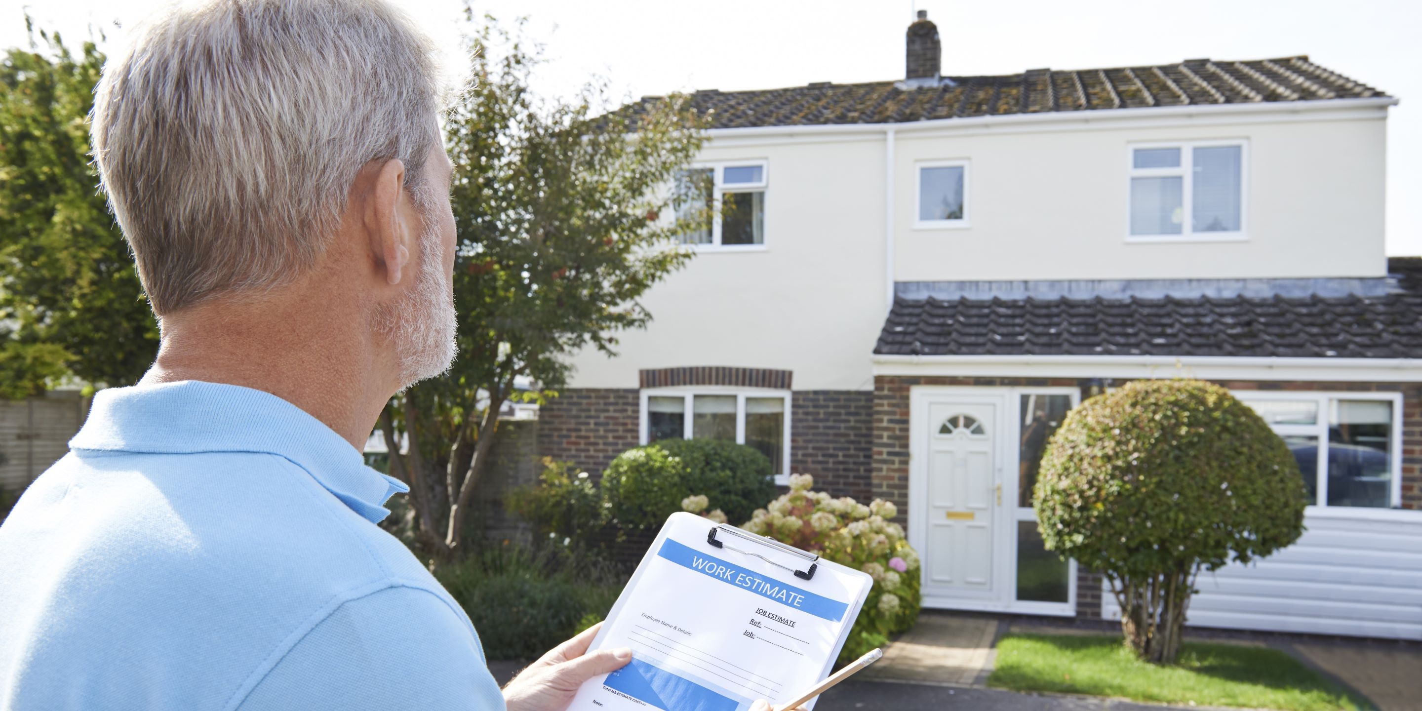 Male taking notes outside exterior of house