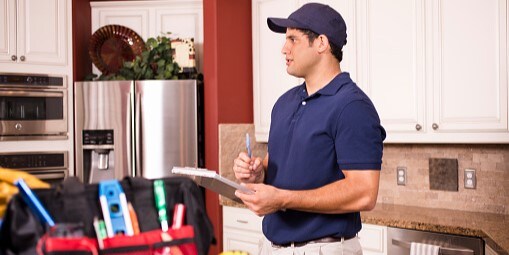 Male contractor with clipboard in kitchen