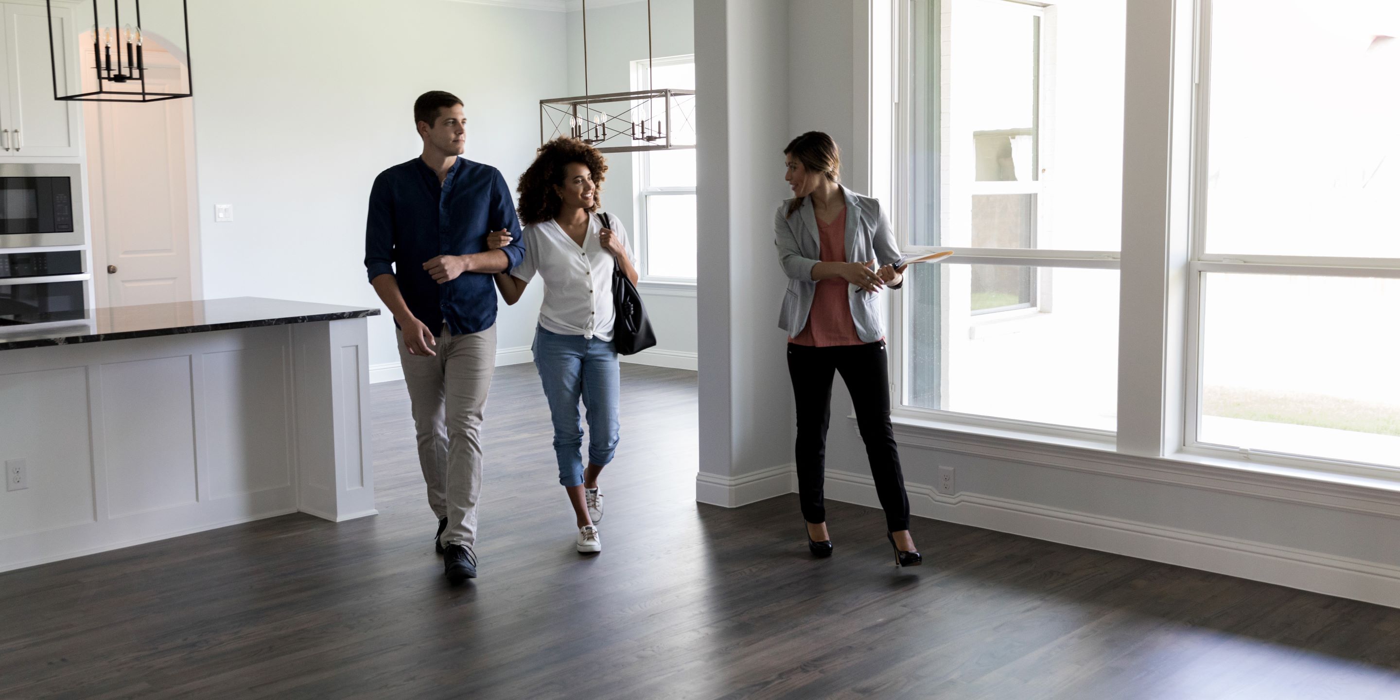 Real estate agent showing empty home to couple