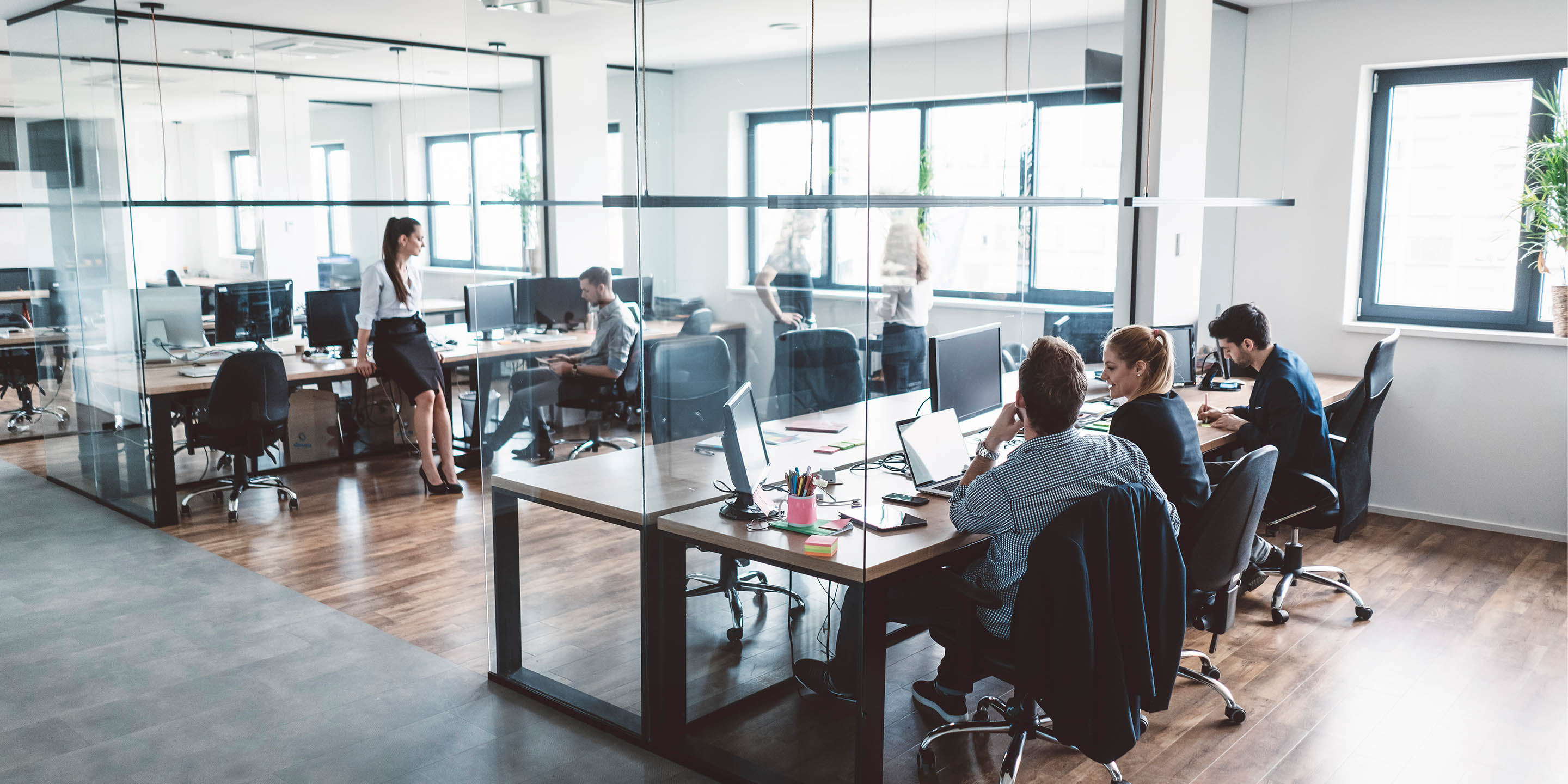 People working at desk in middle of office
